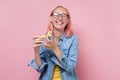 Woman with pink dyed hair and glasses eating a piece of pizza Royalty Free Stock Photo