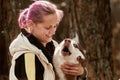 Woman with pink hair hugs Siberian Husky dog, true love of owner and pet, funny emotions