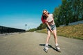 Woman with pink hair rides on roller skates.