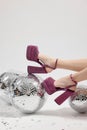 Woman in pink high heeled shoes and disco balls on white background, closeup Royalty Free Stock Photo