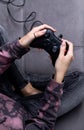 Woman in pink hoodie with manicured hands hold gamepad