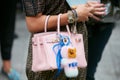 Woman with pink leather bag with pink Fendi fur puppet before Emporio Armani fashion show,