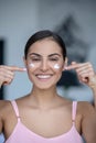 Woman in pink lingerie applying cream on her face Royalty Free Stock Photo