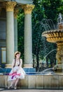 Woman with a pink rifle sitting by the fountain Royalty Free Stock Photo