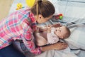 A woman in a pink shirt sits on the floor in living room and plays with her little child. Child really likes to play. Royalty Free Stock Photo