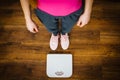 Woman with pink sneakers on bathroom weight scale Royalty Free Stock Photo