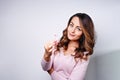 Woman in pink sweater with pink ribbon supporting breast cancer awareness campaign