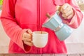 Woman in pink sweater pouring coffee from Moka Pot Royalty Free Stock Photo