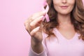 Woman in pink sweater with pink ribbon supporting breast cancer awareness campaign