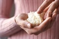 Woman in pink top holding raw shea butter or karite