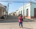 Woman in pink walks along street