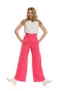 Woman In Pink Wide Legs Trousers Is Standing Legs Apart, Holding Hands In Pockets And Smiling Royalty Free Stock Photo