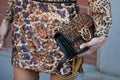 Woman with Pinko leopard skin pattern bag and sequin skirt before Fendi fashion show, Milan