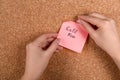 Woman pinning paper note with phrase Call Mom to cork board, closeup