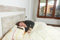 Woman placidly sleeping in bed in her large bedroom. Royalty Free Stock Photo