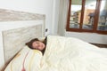 Woman placidly sleeping in bed in her large bedroom. Royalty Free Stock Photo