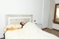 Woman placidly sleeping in bed in her large bedroom. Royalty Free Stock Photo