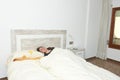 Woman placidly sleeping in bed in her large bedroom. Royalty Free Stock Photo