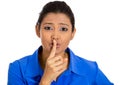 Woman placing finger on lips, pointing at you as if to say, shhhhh, quiet