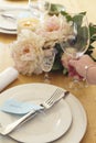 Woman placing a glass into a formal table setting