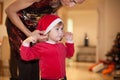 Woman placing hat to baby santa claus