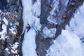 Woman is Placing an Ice Screw. Ice Climbing on Frozen Waterfall, Aerial View. Royalty Free Stock Photo