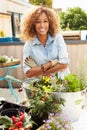 Woman Planting Container On Rooftop Garden