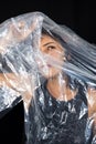 A woman with a plastic bag over her head looking through a hole. Protest against the use of plastic in the world. Environmental Royalty Free Stock Photo