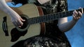 Woman play on the guitar. The fingers of the left hand of the beautiful girl clamp on the strings a chord in E minor. Royalty Free Stock Photo