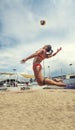 Woman player beach volleyball jumping to hit the ball. Spike