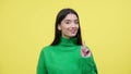 Woman Playfully Waving Finger In Disagree Over Yellow Background