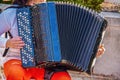 Woman playing accordian outdoors - Selective focus and some motion blur on hands - Colorful and cropped