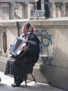 Woman playing accordion on Berlin sidewalk