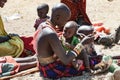 Masai Woman playing with baby , People of Maasai Tribe sitting on ground, Tanzania, Africa