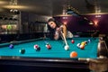 Woman playing billiard and using bridge rack