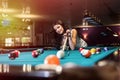 Woman playing billiard and using bridge rack