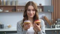 Woman playing with cakes indoors. Funny girl having fun with colorful donuts. Royalty Free Stock Photo