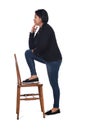 Woman playing with a chair in white background,profile hands on chin