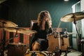 Woman playing drums during music band rehearsal