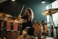 Woman playing drums during music band rehearsal