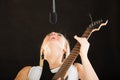 Woman playing on electric guitar and singing