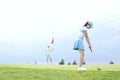 Woman playing golf with female friend against sky Royalty Free Stock Photo