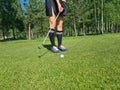 Woman playing golf view of legs and putter and ball Royalty Free Stock Photo