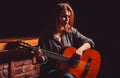 Woman playing guitar, holding an acoustic guitar in his hands. Girl play the guitar. Woman hipster man sitting in a pub Royalty Free Stock Photo