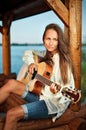 Woman playing guitar in summerhouse