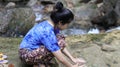 Woman playing Hands on water in a waterfall.