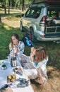 Woman playing harmonica with friend in campsite Royalty Free Stock Photo