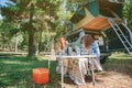 Woman playing harmonica with friend in campsite Royalty Free Stock Photo
