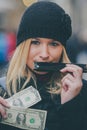 Woman playing harmonica and holding money Royalty Free Stock Photo