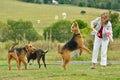 Woman playing with her large pet Airedale Terrier dogs outdoors